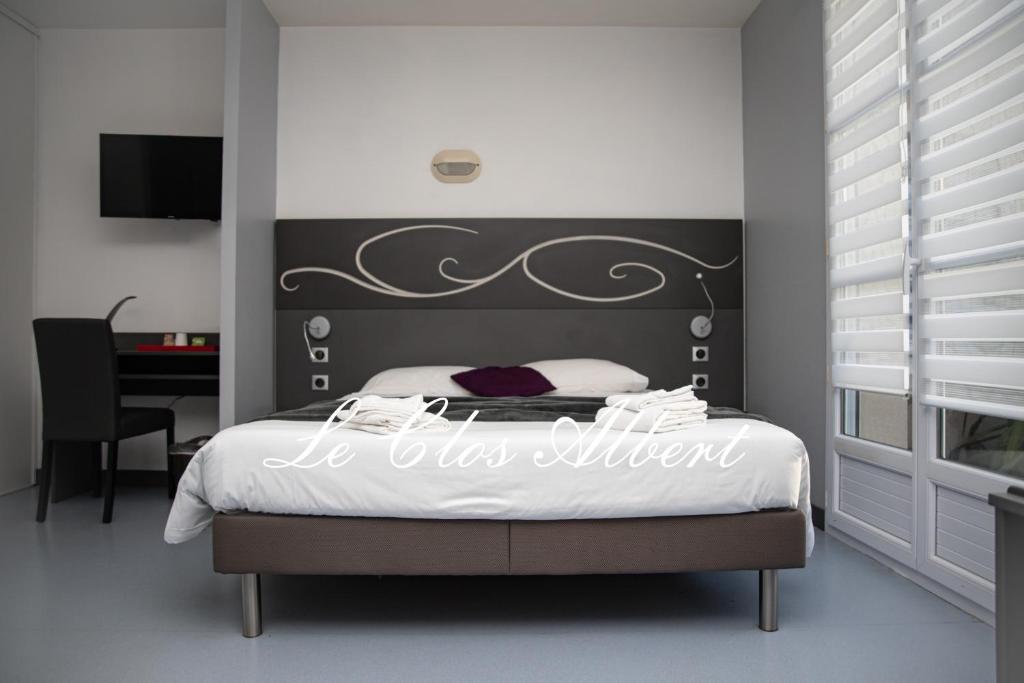 卢丹Le Clos Albert的一间卧室配有一张带黑白床头板的床