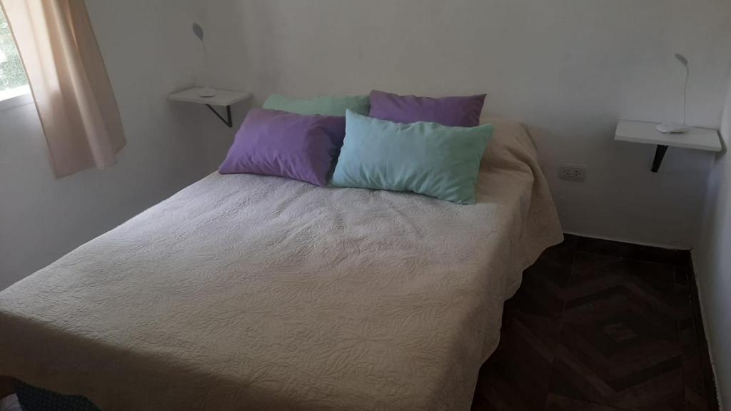 卢汉德库约Paz y Vino的一张床上有三个枕头的房间