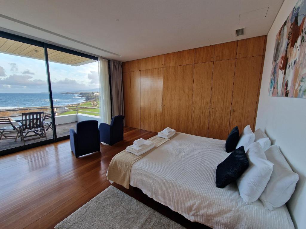 卡佩拉什São Vicente Lodge - Panoramic Retreat的一间卧室设有一张床,享有海景