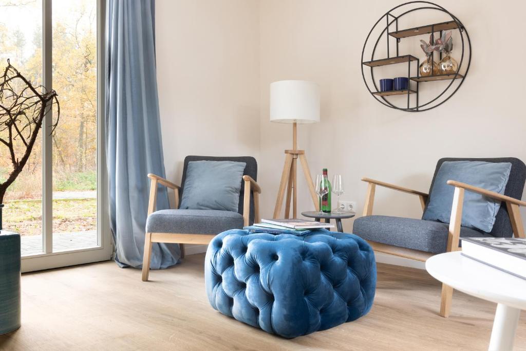LüderFerienwohnungen in Wald und Flur - Wohnung Wald的客厅配有两把椅子和蓝色的搁脚凳