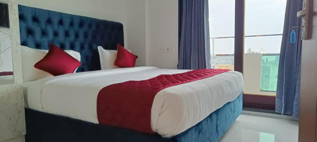 蓬蒂切里NMS GRAND VIEW TOWER的一间卧室配有一张带红色枕头的大床