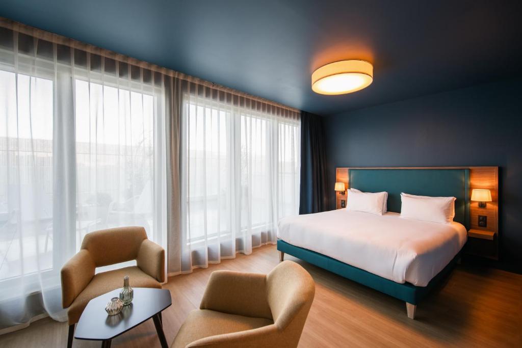 南特Hôtel de la Cité的酒店客房,配有一张床和两把椅子