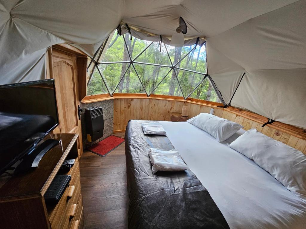 Manzanar智利漩涡生态山林小屋的帐篷内一间卧室,配有一张大床