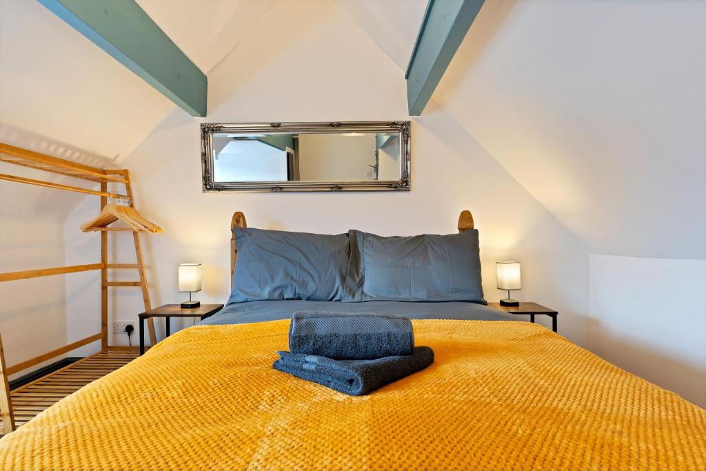 尤托克西特Sally’s Cottage - Uttoxeter: Close to Alton Towers的卧室配有一张黄色的床,墙上装有镜子