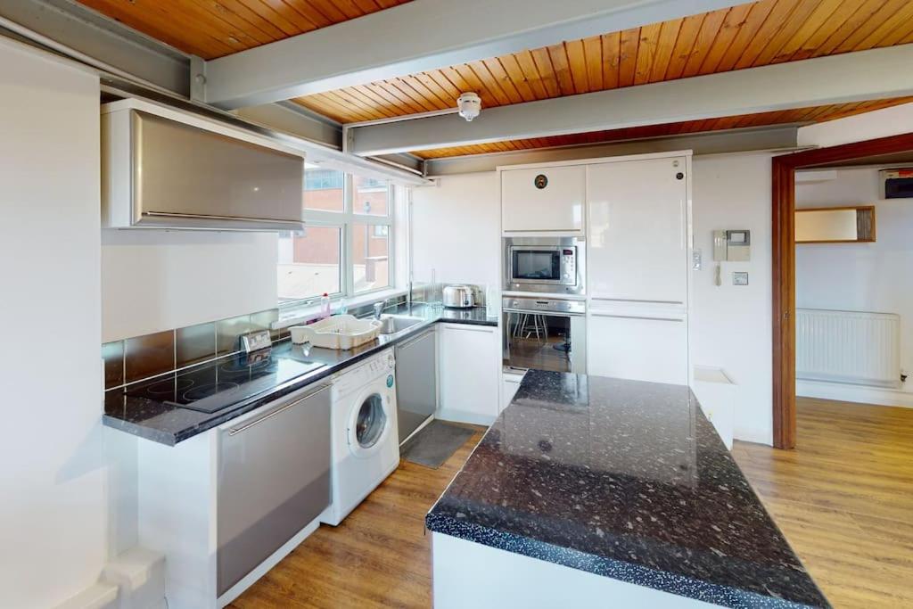 诺丁汉Central Nottingham sleeps up to 4的厨房配有白色家电和黑色台面