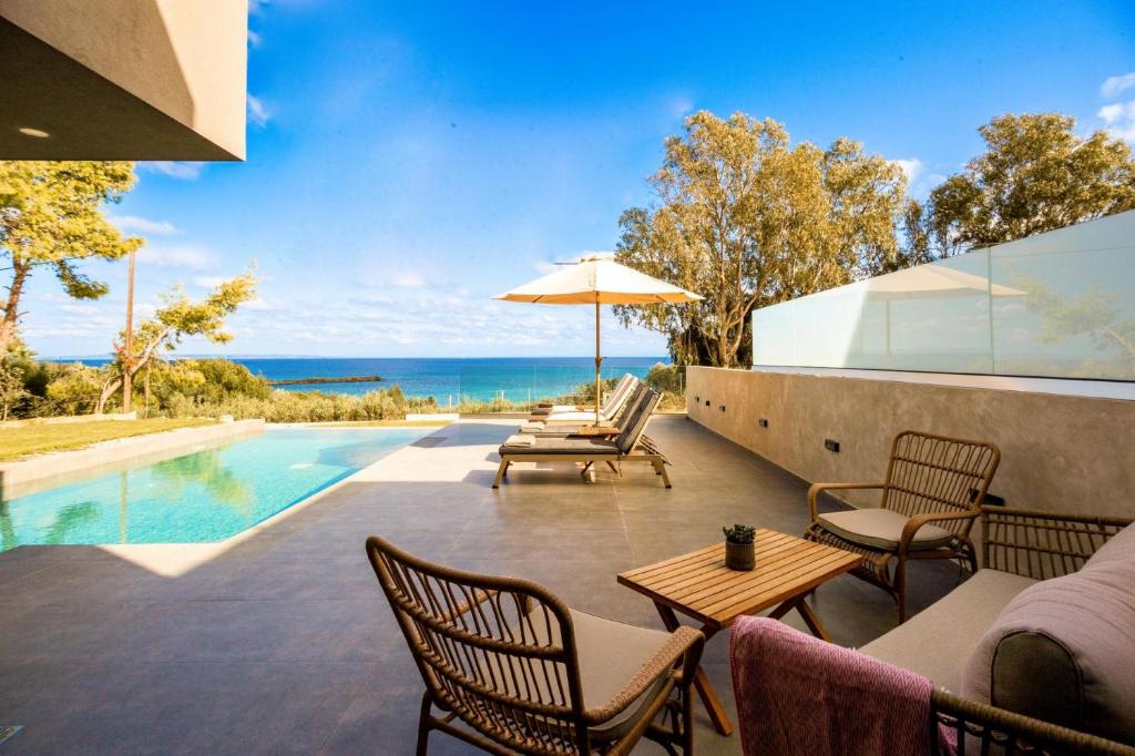 瓦西里科斯Luxury Villa Mon I Vassilikos的一个带桌椅的户外庭院和一个游泳池