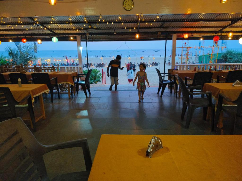 巴加Oceanside Beach House-By Roseal的男人和孩子在餐馆里走