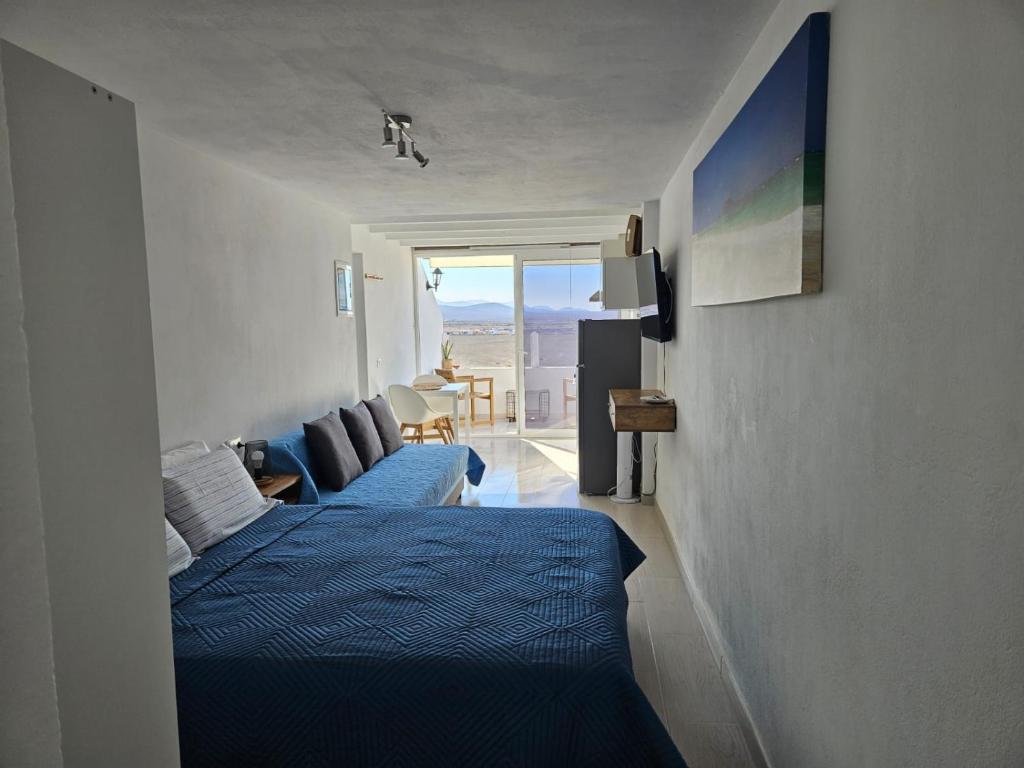 科蒂略Apartamentos Cotillo Family的一间带蓝色床的卧室和一间客厅