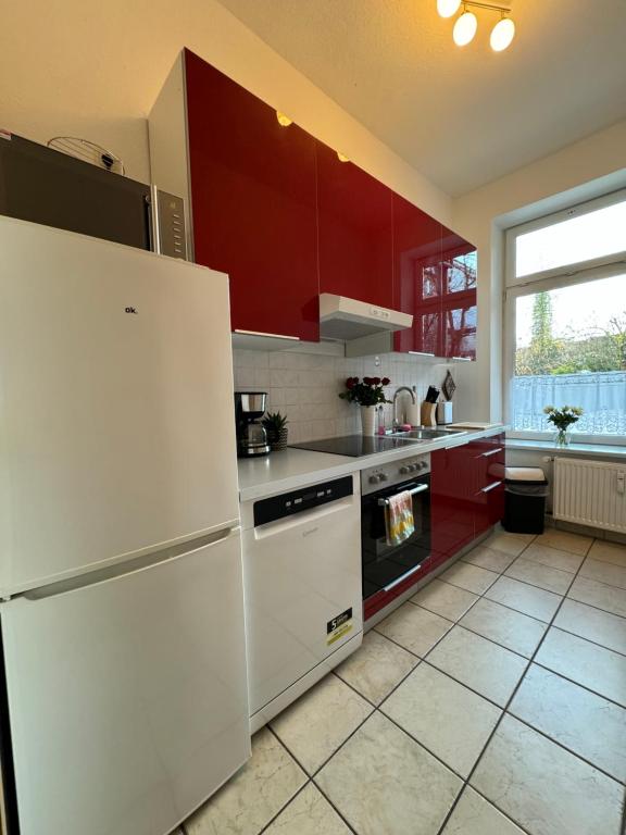 什未林Attraktive Wohnung im grünen Hinterhof的厨房配有白色冰箱和红色橱柜