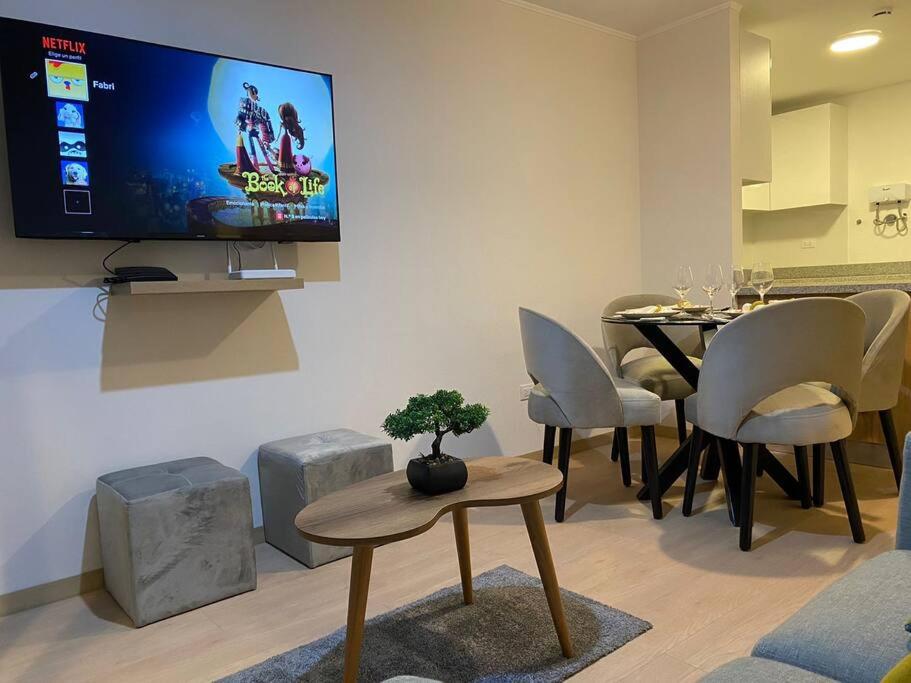 利马Apartamento en Barranco的客厅配有桌子和墙上的电视