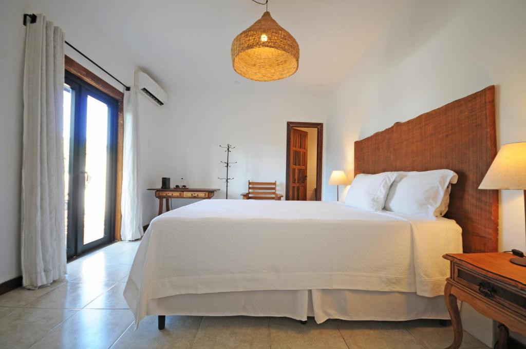 布希奥斯Villa Santa Fé的卧室设有一张白色大床和一扇窗户。