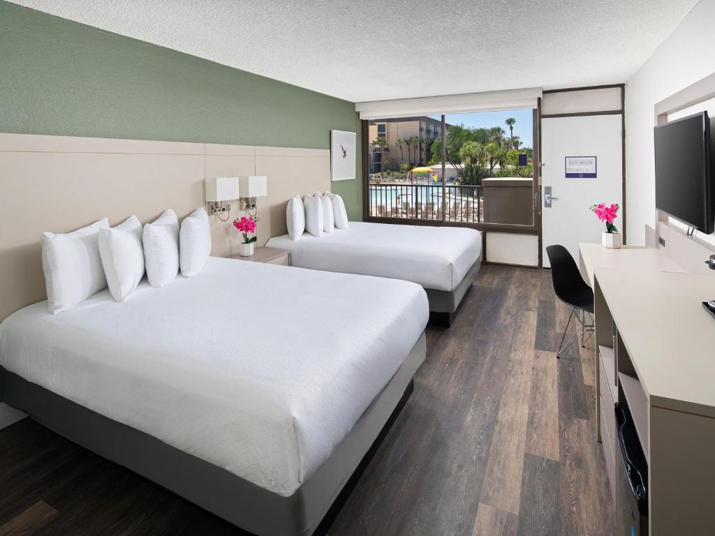 奥兰多阿凡提棕榈度假酒店的酒店客房设有两张床和一台平面电视。