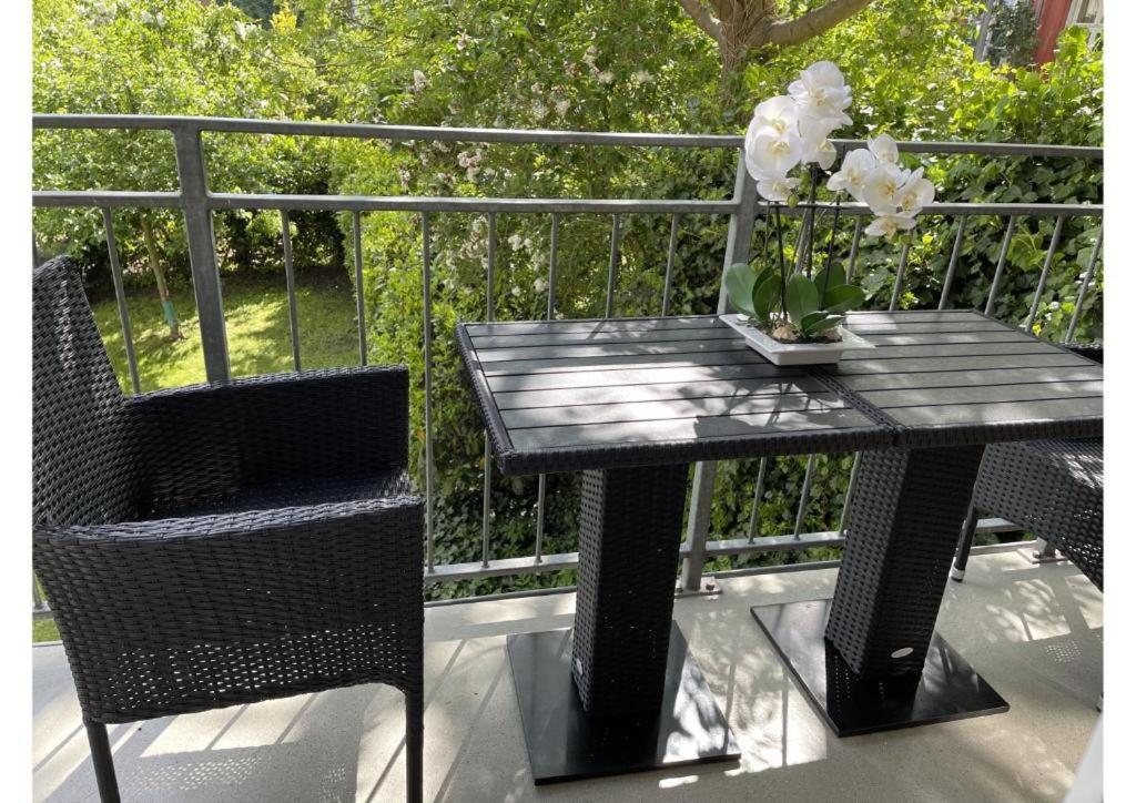什未林Schicke Wohnung im grünen Hinterhof的阳台上摆放着黑色桌子和椅子,上面摆放着鲜花