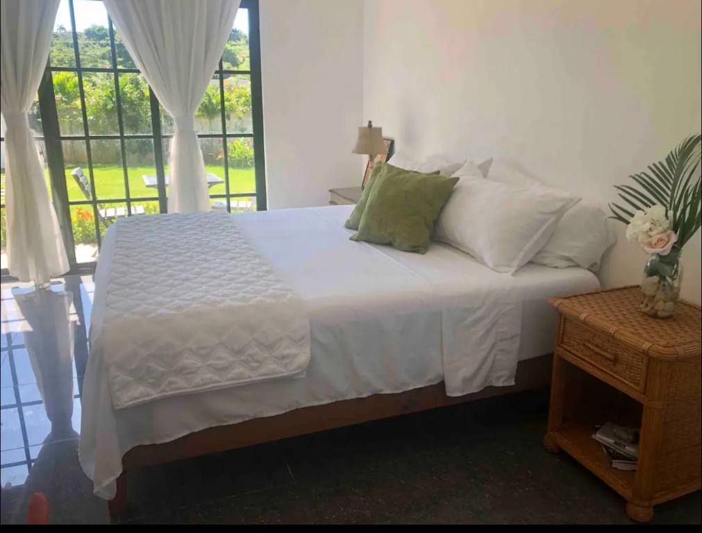 拉斯加勒拉斯Stylish room by the beach的一间卧室配有一张带白色床单的床和一扇窗户。