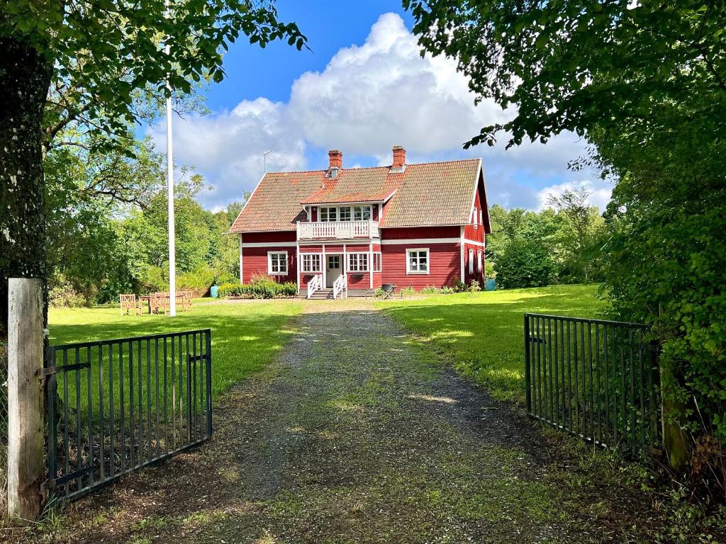 SkinnskattebergSjönära lantgård i Bergslagen的前面有栅栏的红色房子