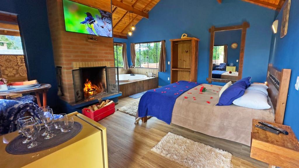 蒙特韦尔迪Chalés Mirante das Pedras的一间卧室配有一张床、一个壁炉和一台电视。