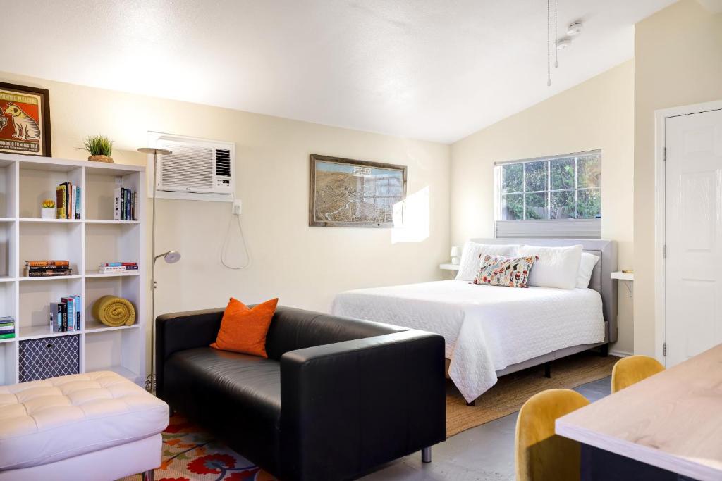 圣安东尼奥Marfa - A Birdy Vacation Rental的一间卧室配有一张床和一张黑色皮沙发