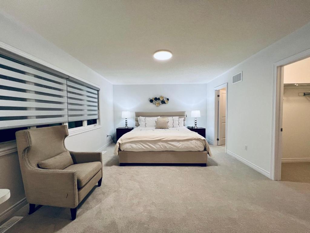 巴里Brand New! Modern Luxury Retreat!的卧室配有床、椅子和窗户。