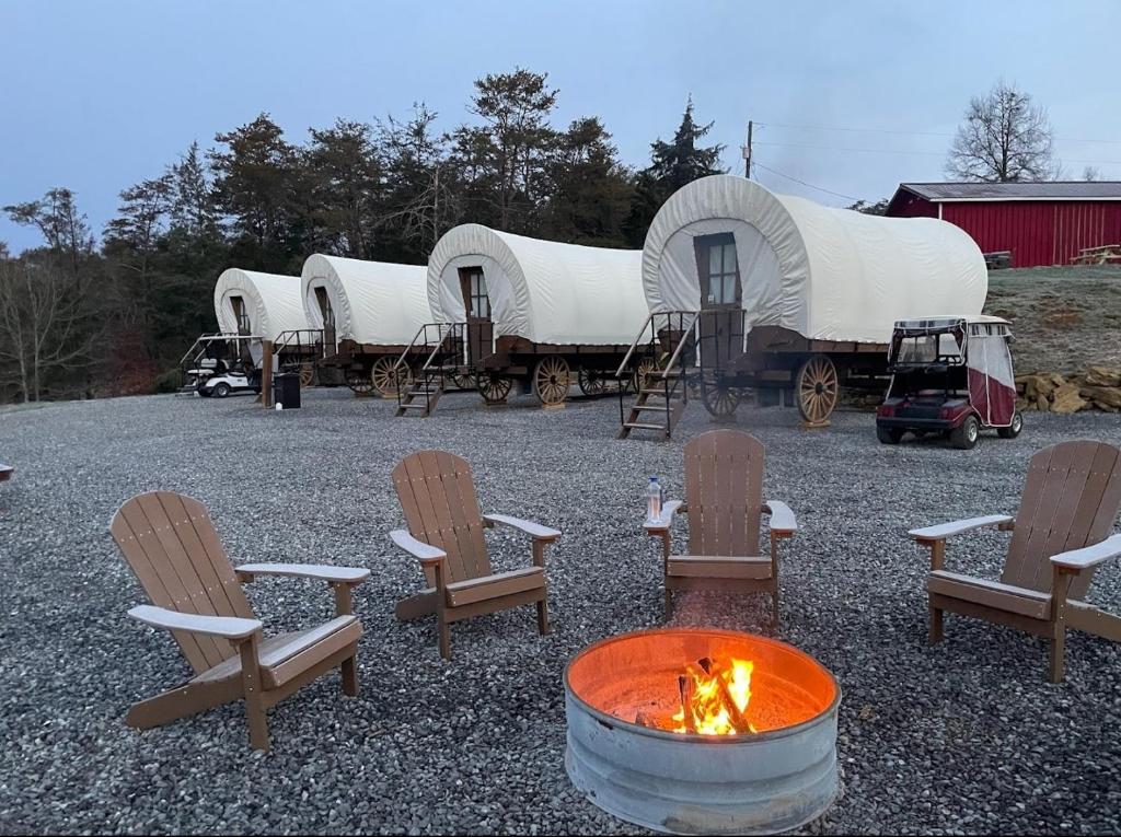 赛维尔维尔Smoky Hollow Outdoor Resort Covered Wagon的一组圆顶,配有椅子和火坑