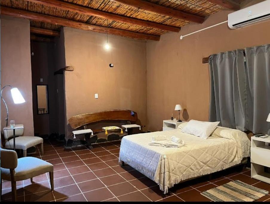 蒂诺加斯塔Hotel de campo luna的卧室配有1张床、1张桌子和1把椅子