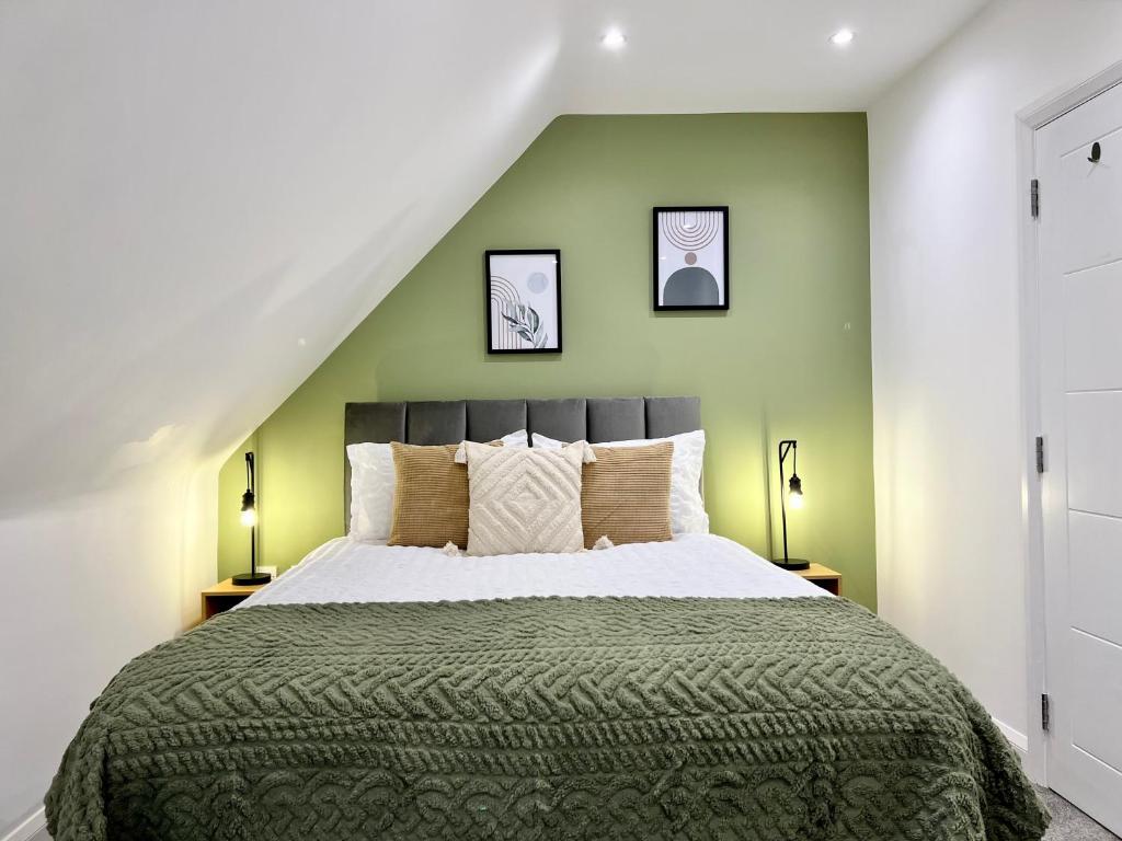 博勒姆伍德2-bed flat in central Borehamwood location的一间卧室设有一张带绿色墙壁的大床