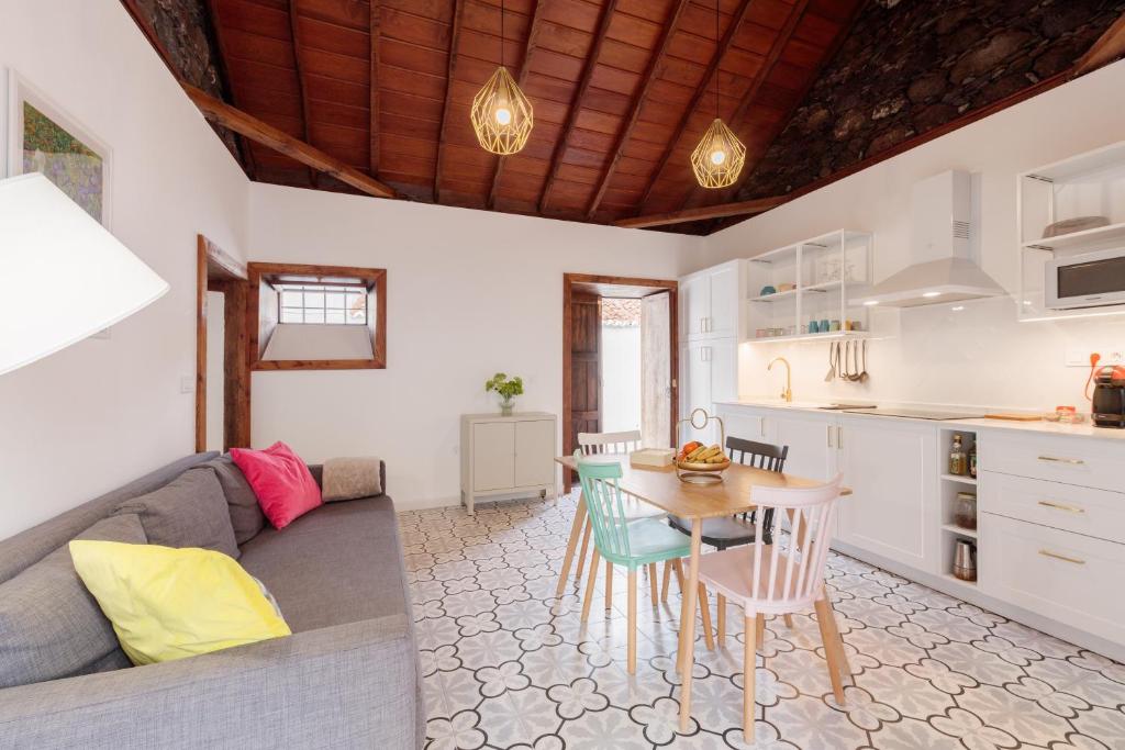 洛斯·亚诺斯·德·阿里丹Casa Canaria Azucena的厨房以及带沙发和桌子的客厅。
