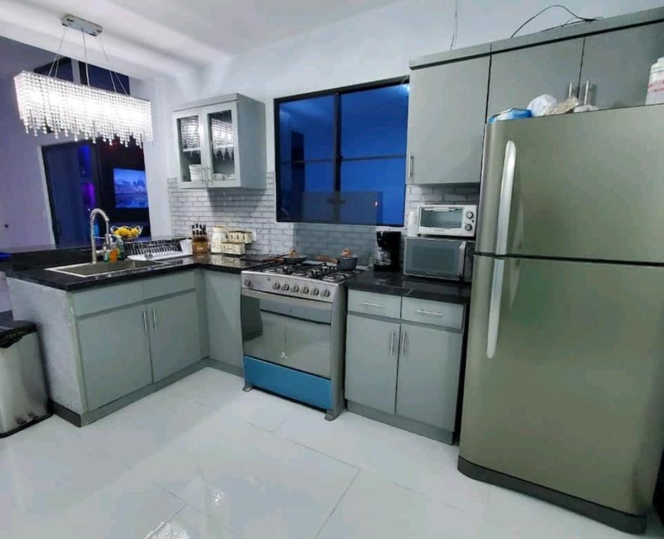 松索纳特Marhabibi's home的一个带不锈钢用具的厨房和一个大窗户