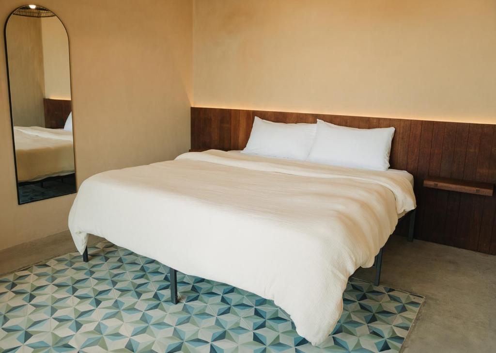 El PorvenirEqu Hotel de Tierra的卧室配有一张带镜子的白色大床