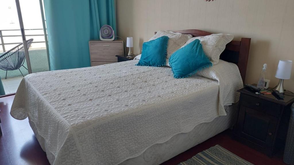 伊基克Departamento frente a Playa Brava的一间卧室配有一张带蓝色枕头的床。