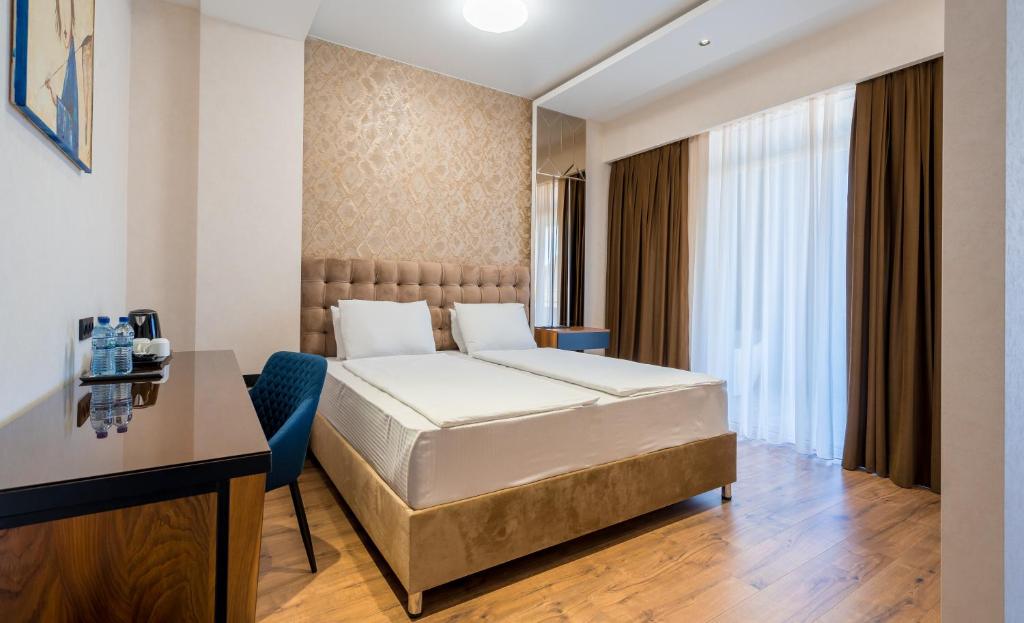 第比利斯Olympus Hotel By Umbrella的配有一张床和一张书桌的酒店客房