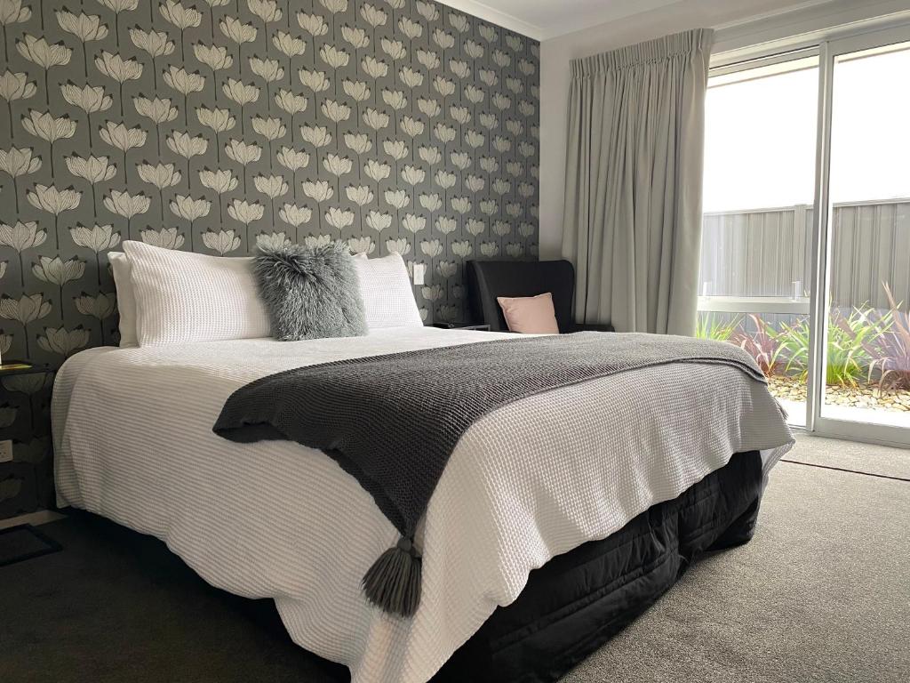克伦威尔Lakeview Terrace Accommodation的一间卧室配有一张带花卉墙壁的床