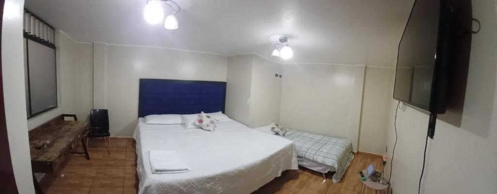 利马HOME BLESSED II的卧室配有白色的床和电视。