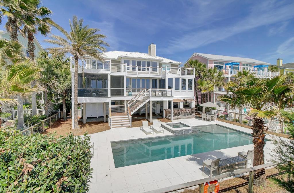棕榈岛910 Ocean Boulevard的一座带游泳池和棕榈树的大型白色房屋