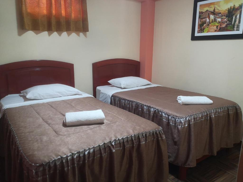 塔克纳Hotel lucero real的两张位于酒店客房的床,配有毛巾