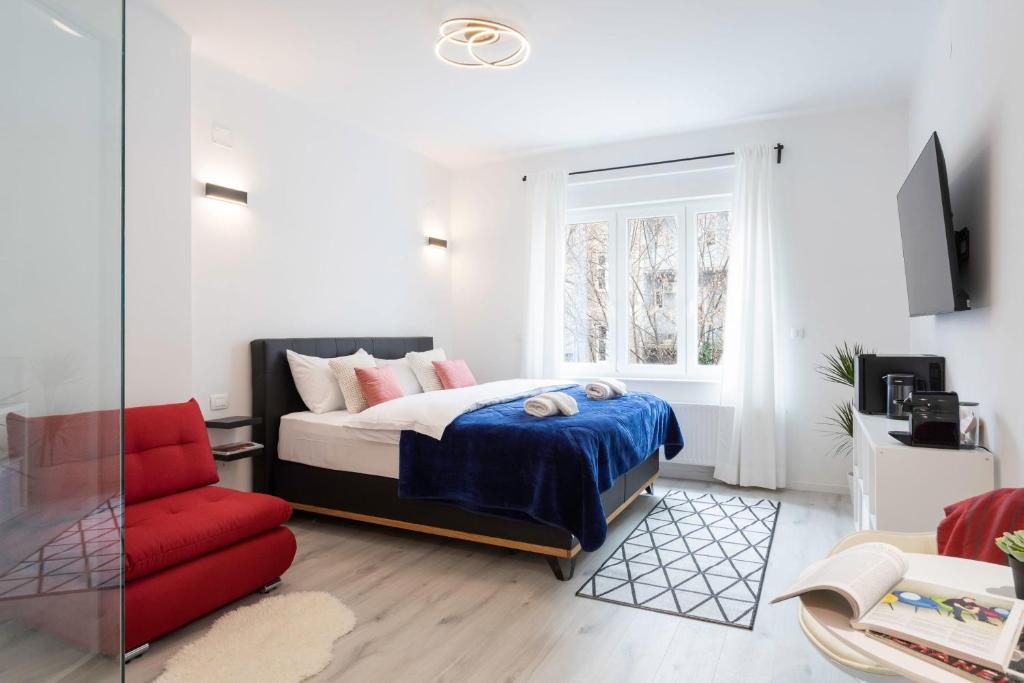 萨格勒布Lux Nest II City Apartment URBAN STAY的一间卧室配有一张床和一张红色椅子