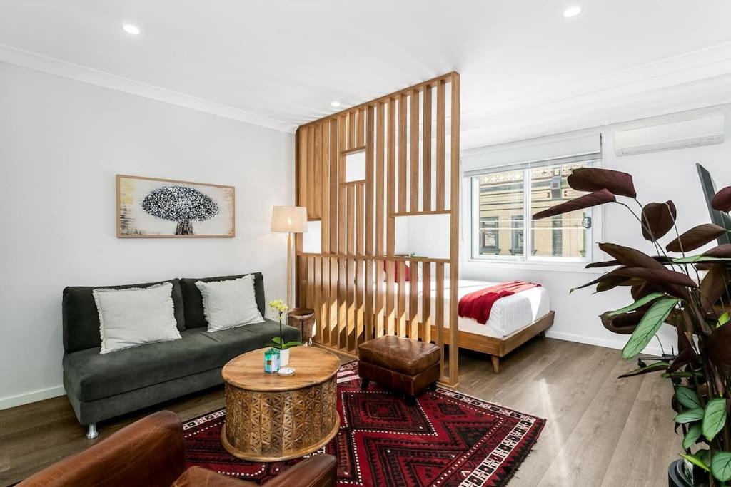 悉尼Studio Apartment in the heart of Newtown NMORE的客厅配有沙发和1张床