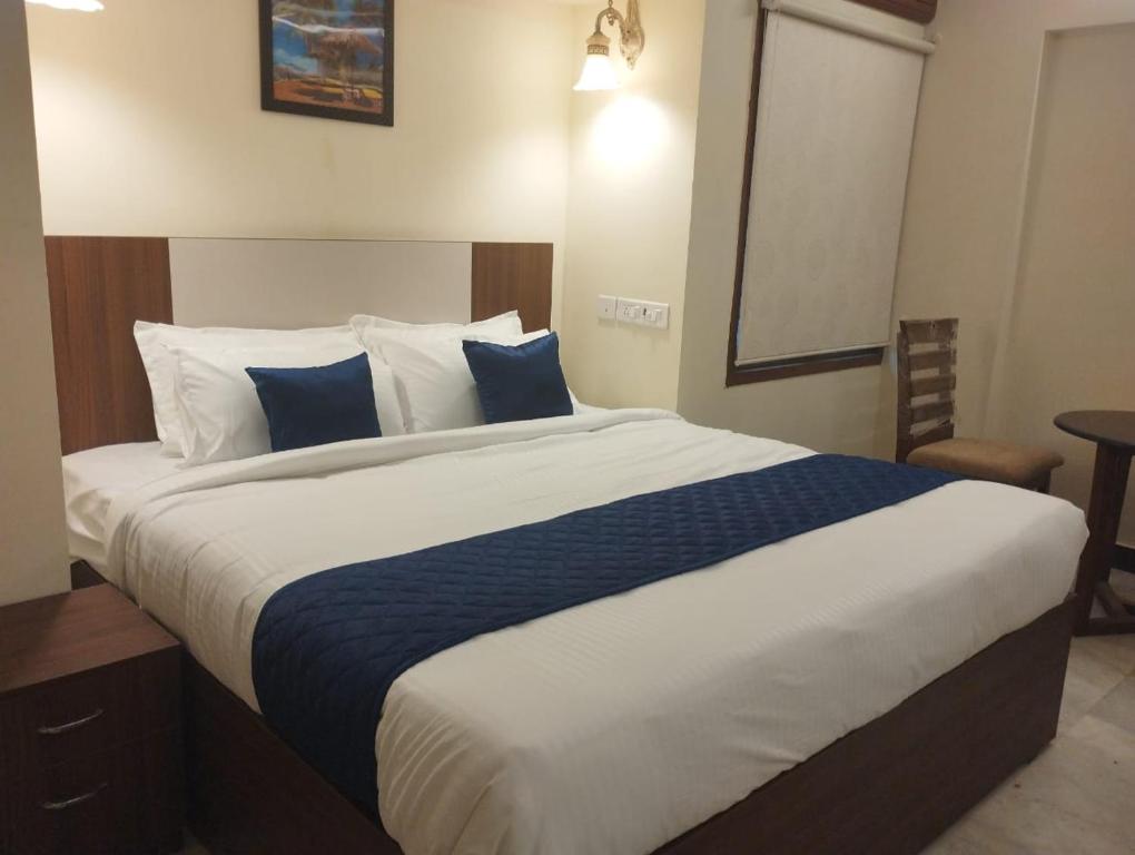 钦奈A.R Residency的一间卧室配有一张带蓝白色枕头的大床