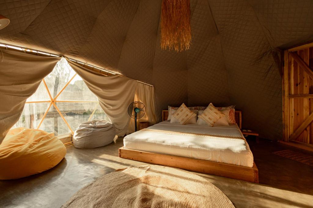 爱妮岛Domes and Dreams Lio Glamping的帐篷内一间卧室,配有一张床