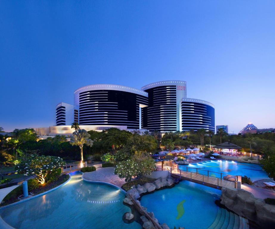 迪拜迪拜君悦公寓的享有带两个游泳池和大楼的度假村景色