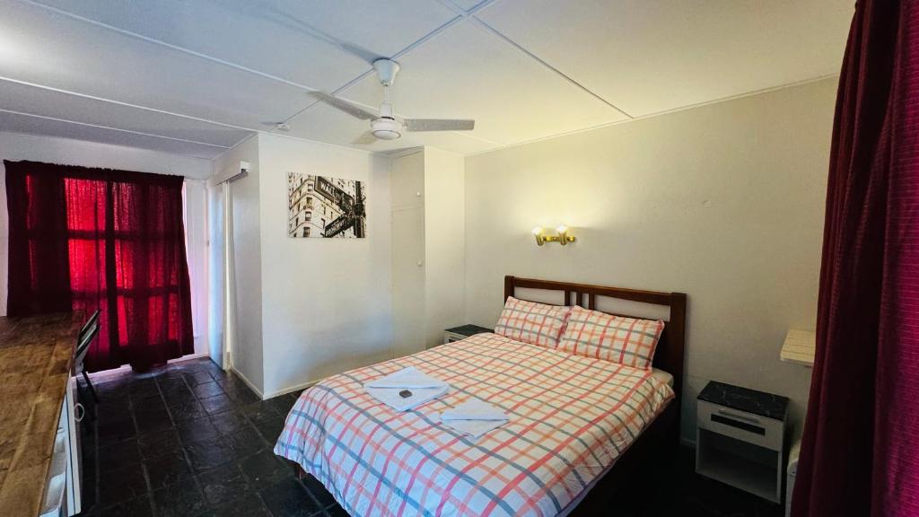 ColosseumColosseum Creek Motel的一间带一张床和吊扇的小卧室
