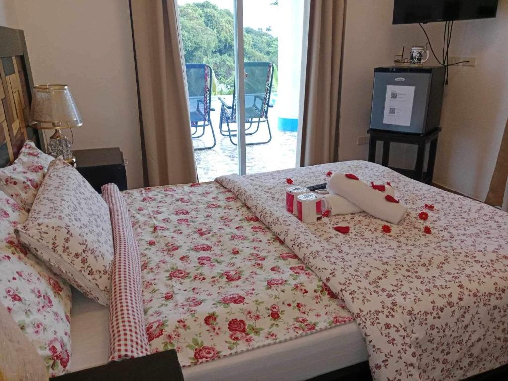 BolinaoCouple room in Final Destination Resort的一间卧室配有一张带玫瑰毛毯的床