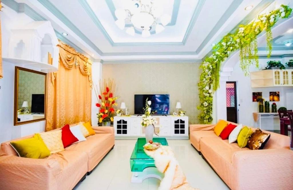 宿务Spacious House in Talamban, Cebu City的客厅配有两张沙发,桌子上坐着一只猫