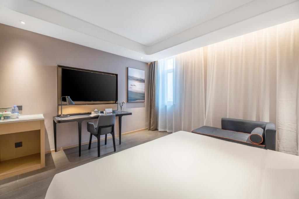 西安西安浐灞会展中心世博园亚朵酒店的配有一张床和一张书桌的酒店客房