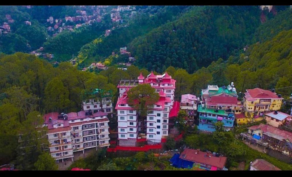 西姆拉Hotel White Grand Shimla-near ISBT bus stand- Fully Air Conditioner的山上一群有红色屋顶的建筑