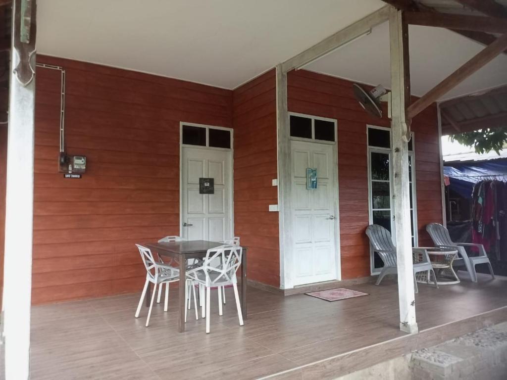 瓜拉丁加奴Bilik Bajet RM70-RM90的房屋内的门廊配有桌椅