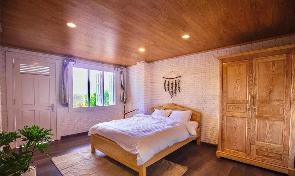 大叻Scent Village Hotel的一间卧室设有一张床和一个窗口