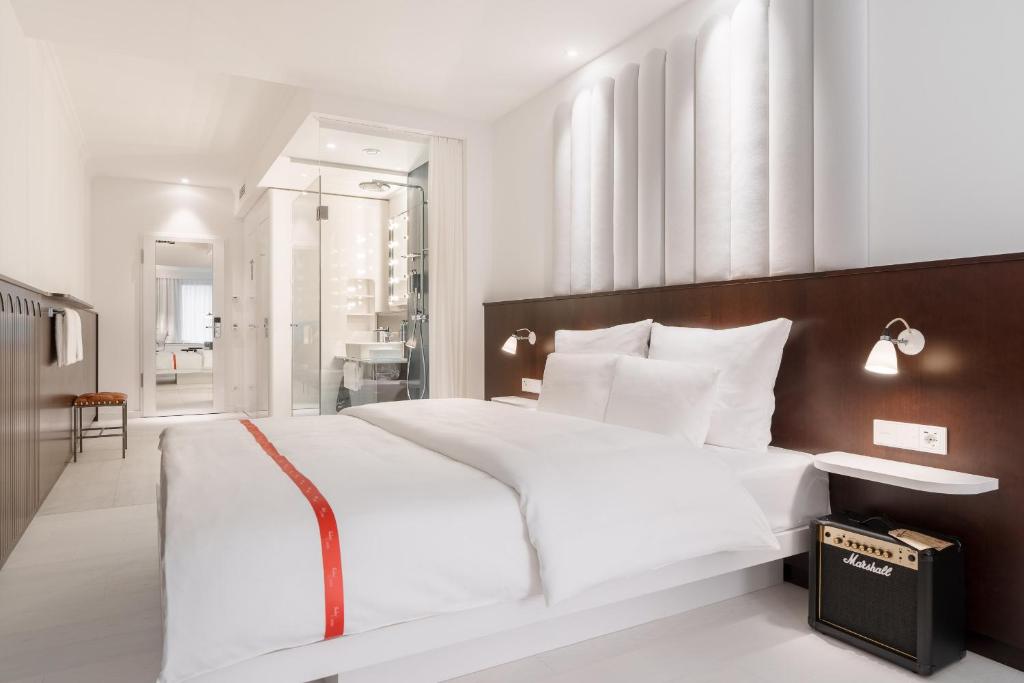 斯图加特Ruby Hanna Hotel Stuttgart的卧室配有一张白色大床和木制床头板