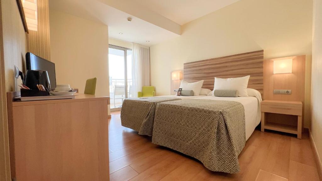 贝尼多姆Riviera Beachotel - Adults Recommended的酒店客房,配有床和电视