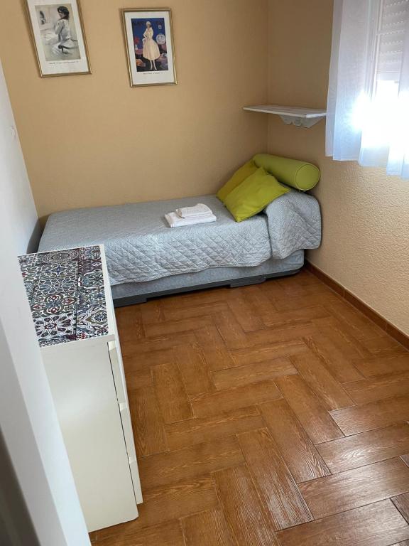 塞维利亚Familia anfitriona acoge的一间铺有木地板的小卧室,配有一张床