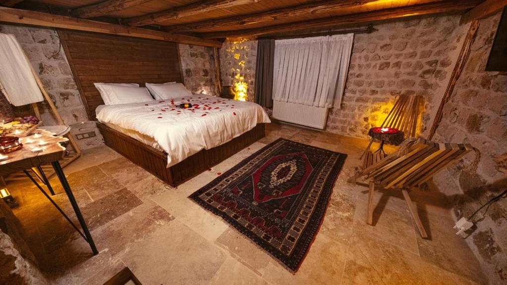 Narcrassula cave kapadokya hotel的一间卧室配有一张床和一张带台灯的桌子